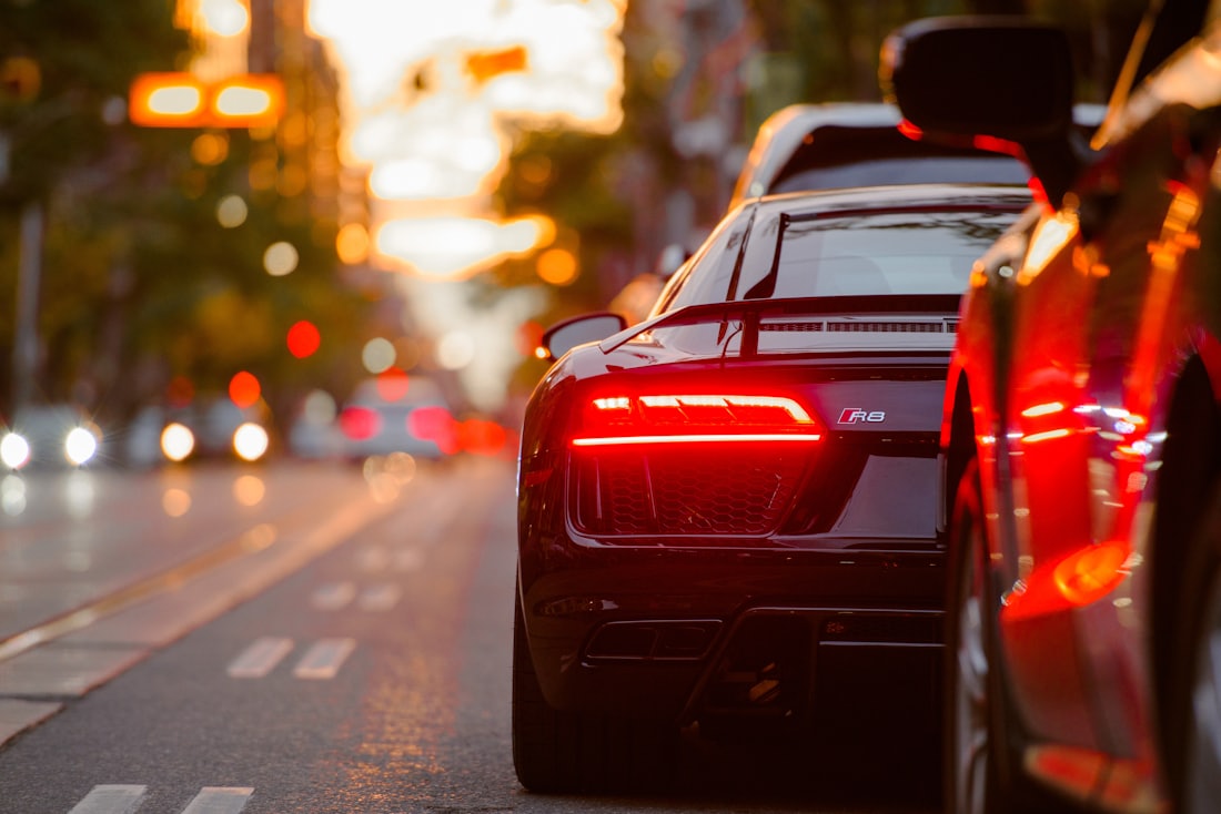 A car on the road at dusk, brake lights glowing
