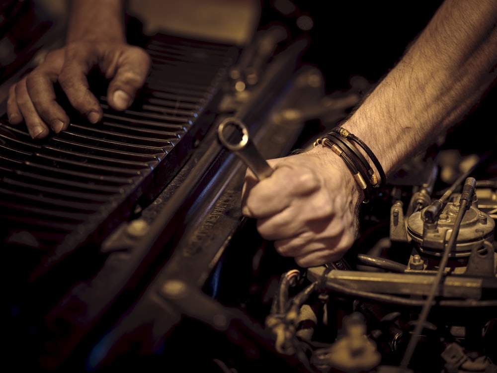 Close-up of a technician's hands working a spanner on an engine