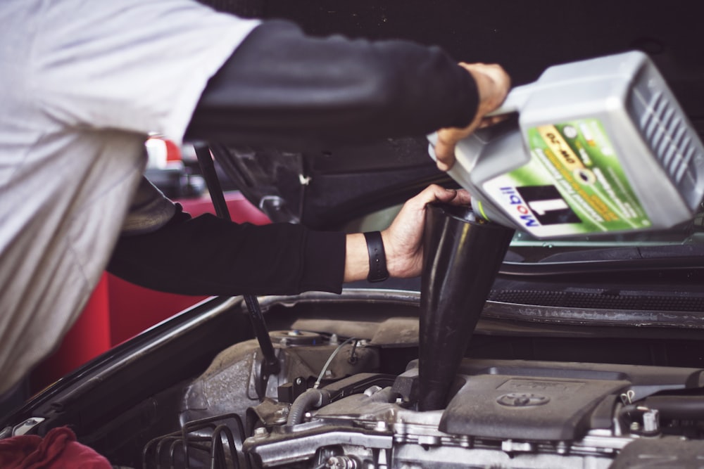 Mechanic servicing a car engine under the bonnet